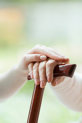 Caregiver's hand on elder's hand