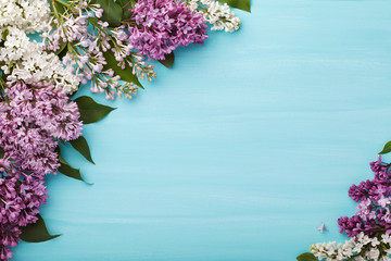 Bunch of lilac flowers on a turquoise wooden background. Top view, flat lay.