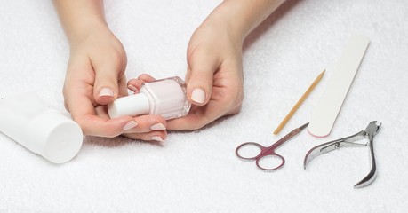 Close-up of female hands doing manicure at home.