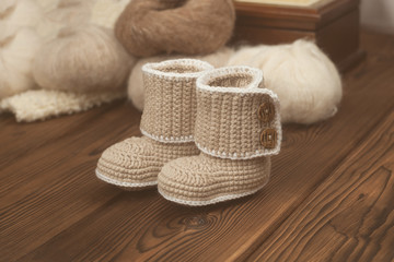 Fototapeta na wymiar baby winter knitted booties on wooden background