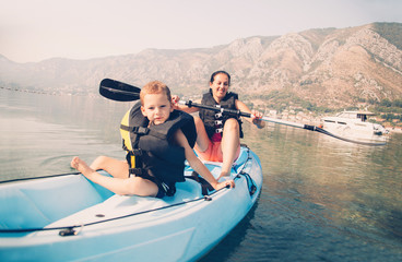Mother and son kayaking at the sea
