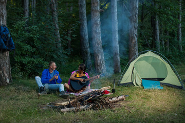 Camping couple. Couple in love. Camping fire. Couple. Girl guitar. Man nature. Forest. Love story. Love concept. Sensual.