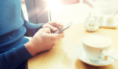 close up of man with smartphones at cafe