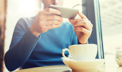 close up of man with smartphones at cafe