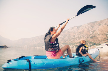 Mother and son kayaking at the sea