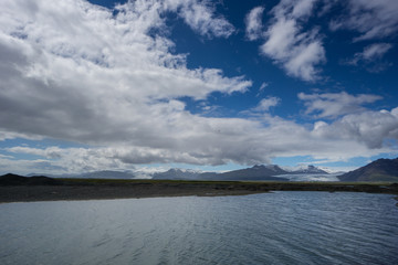 Iceland - River with two glaciers behind in mountainous volcanic landscape
