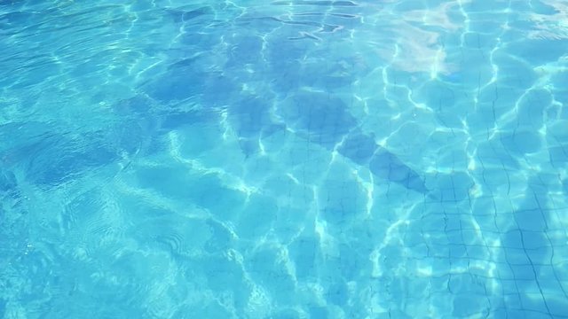 Refraction of sunlight in swimming pool water. Pool water surface, sparkles on the water in slow motion. 1920x1080