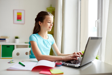 Obraz na płótnie Canvas happy girl typing on laptop at home