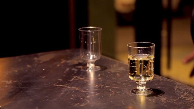 Cinemagraph of bubble bubbling in small glass of champagne on the table
