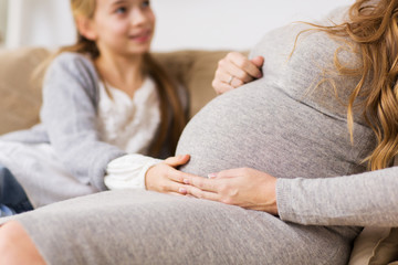 close up of pregnant woman and girl at home