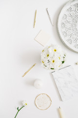 Flat lay home office desk. Woman workspace with chamomile flowers bouquet on white background. Top view feminine background.