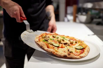 Foto op Aluminium koken met gebakken pizza op schil bij pizzeria © Syda Productions