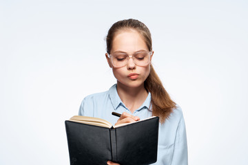 Obraz premium Woman working in glasses on white isolated background writing in notebook, portrait