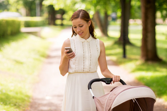 happy mother with smartphone and stroller at park