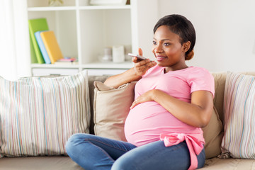 pregnant woman using voice recorder on smartphone