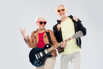 senior couple with guitar showing rock hand sign