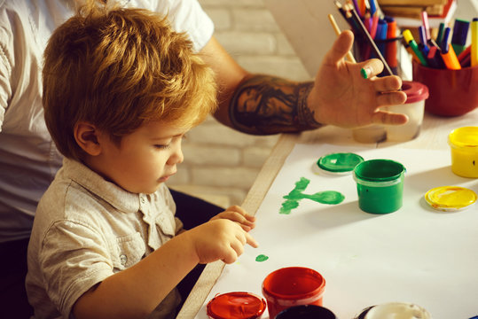 Kid fingerprints art. Funny lessons, homework, lessons in kindergarten. Child draws picture with hands. Cute boy with father paints green grass. Art therapy for anxious children, cure for stress free