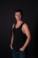 Fototapeta na wymiar Portrait of sporty man in black t-shirt. Caucasian male model in studio shoot.