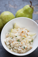 Close-up of risotto with pears served in a white bowl, selective focus