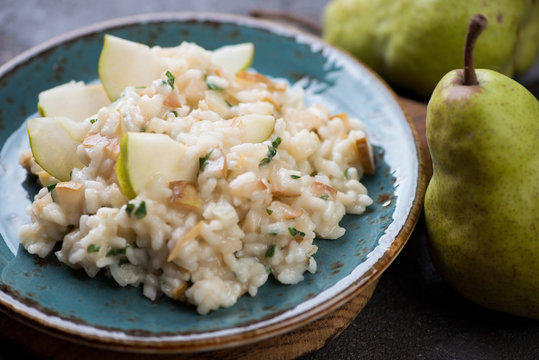 Close-up of pear risotto served on a turquoise plate, selective focus