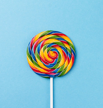 Tasty appetizing Party Accessory Sweet Swirl Candy Lollypop on Blue Background Top View