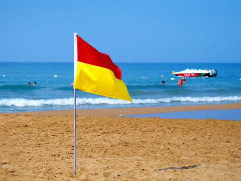 Red And Yellow Flag On Beach Marking Safe Swimming Area