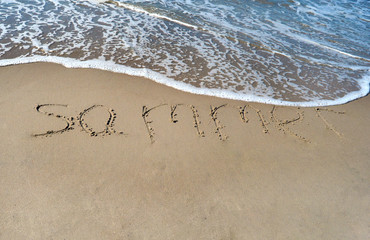 The word summer on the beach background