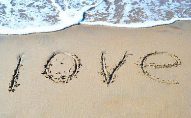 The word love on the beach background