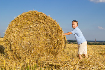 Naklejka na ściany i meble child in a field of straw bale