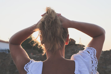 beautiful young woman looked the sunset with a white dress
