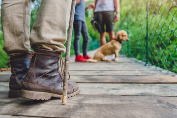 Family with dog on wooden suspension bridge