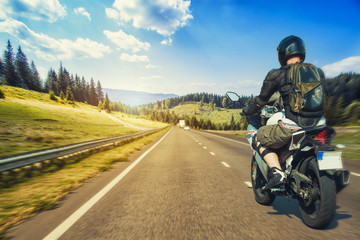 Motorcyclist rushes along the picturesque mountain highway