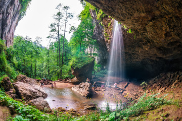 Beautiful scenic summer landscape of Chinarev waterfall in a gorge viewed from inside a rocky grotto in Caucasus mountains by Mezmai village, Russia © Wilding