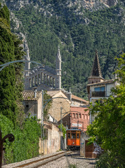 Vintage tram in Soller Majorca, Mallorca island, Balearic Islands, Spain. Mountains beautiful landscape and part of the facade of the church