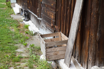 Wooden barn with rubber-soled felt boots standing in front of it