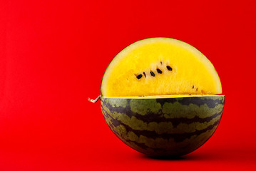 Watermelon with yellow flesh on a red background
