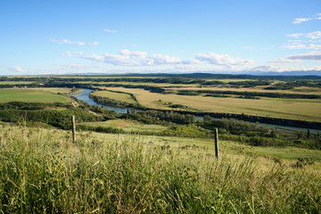 Landscape of the Bow River in Alberta, Canada, during the early summer.  A train track runs next to the river.