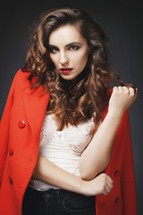 Beautiful young woman posing in studio over grey background. Fashion concept.