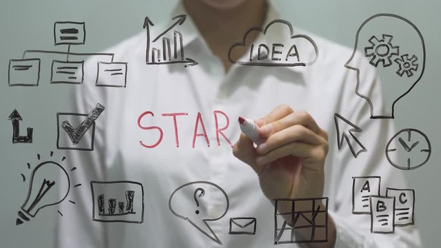 Start Up concept. Woman writing and drawing on transparent screen.