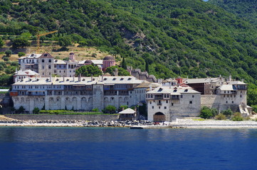Fototapeta na wymiar Athos peninsula, Greece. Xenofontos Monastery located in the Republic of Monks on the peninsula of Athos. View from a cruise ship .