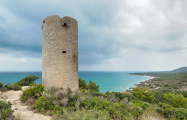 Fototapeta na wymiar Torre de centinela situada sobre un acantilado. Torre Badum en la Sierra de Irta. Peñíscola (Castellón). España.