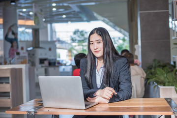 Fototapeta na wymiar Asian young business freelance woman happiness working online business with laptop and cell phone in cafe shop. Working concept.