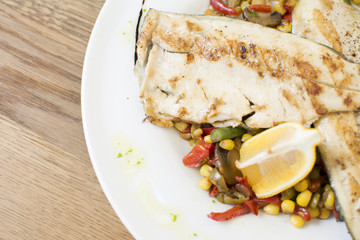 Grill chicken breast. Grilled vegetables with chicken breast. Grilled chicken with vegetables on oak table.