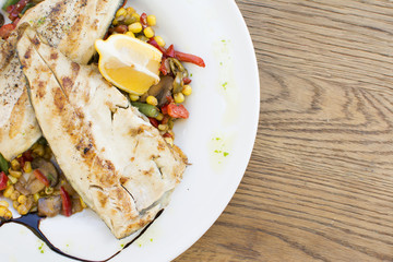 Grill chicken breast. Grilled vegetables with chicken breast. Grilled chicken with vegetables on oak table.