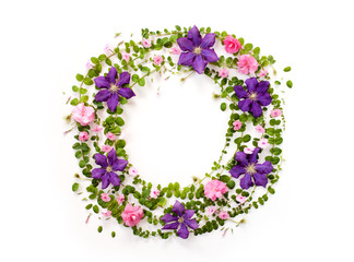 round floral frame with pink and purple flower buds, branches and leaves isolated on white background. flat lay, top view