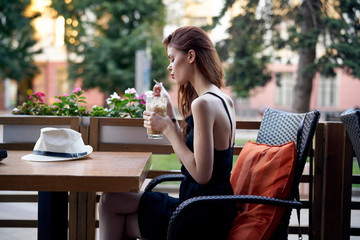 Young beautiful woman in a cafe on the terrace in summer