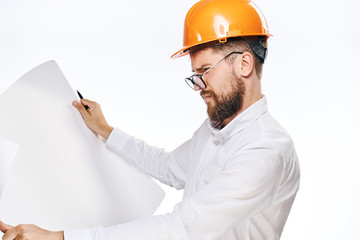 Engineer with a beard and in a helmet holds a drawing, construction, engineering