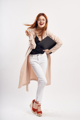 Fototapeta premium Young beautiful woman in glasses on a light background in full growth, smile, fashion, beauty