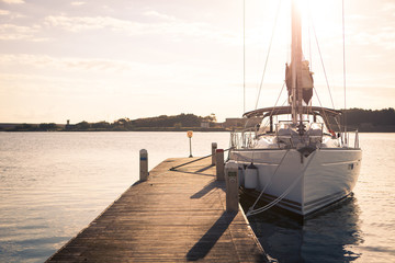 Sailing yacht moored to the pier at sunset
