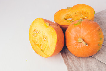 Two mini pumpkins on white background. Studio shot of orange sliced pumpkins on wooden table. Copy space for the text